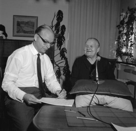 Professori Pertti Virtaranta haastattelee Marina Takaloa kotonaan Risto Rytin tie 28:ssa syyskuussa 1966. Kuva: Museovirasto. CC BY 4.0.