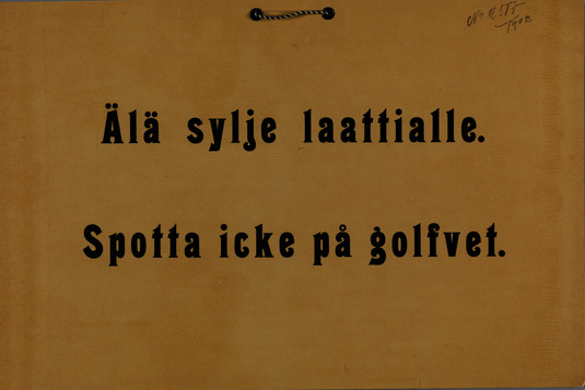 Pahvinen kieltokilpi, jossa teksti: "Älä sylje laattialle. Spotta icke på golfvet." Kuva: Helsingin kaupunginmuseo. CC BY 4.0.