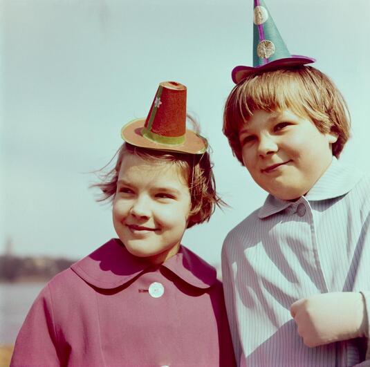 Kaksi lasta värikkäine vappuhattuineen. Helsinki 1960. Kuva: István Rácz. Museovirasto. CC BY 4.0.