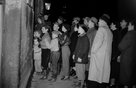 Ihmiset seuraavat televisiolähetystä näyteikkunasta (v. 1955). Kuva: Väinö Kannisto. Helsingin kaupunginmuseo. CC BY 4.0.