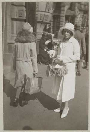 Nuori neitonen kauppaamassa kukkia Helsingin kadulla 1920-luvulla. Kuva: Museovirasto. CC BY 4.0.