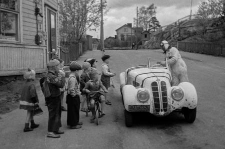 Lapsia, kilpa-ajaja Leo I. Mattila ja BMW-merkkinen kilpa-auto, 1950-luku. Kuva Eino Heinonen. Helsingin kaupunginmuseo