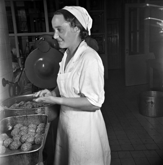 Nainen valmistaa lihapullia keittiössä. Elannon ravintola, nro 5, Hämeentie 11. Helsinki, 1950-luku. Kuva: Helsingin kaupunginmuseo.
