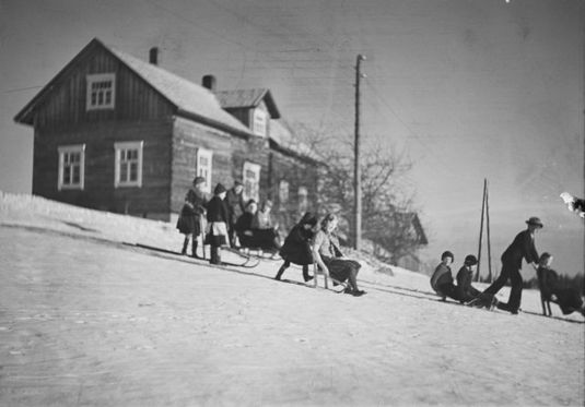 Mäenlaskua laskiaisena Kurkijoen Särkijärvellä. 1930-luku. Kuva: Pekka Kyytinen. Museovirasto. CC BY 4.0.