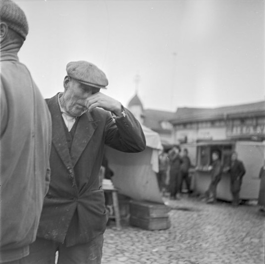 Mies niistää nenäänsä kauppatorilla Vanhan Rauman kaupunginosassa. 1950–1960-luku. Kuva: Raimo Seppälä. Satakunnan museo. CC BY 4.0.