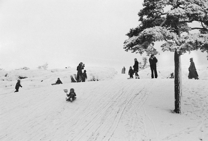 Ensilumi Töölössä vuonna 1973. Mäenlaskua Hietakannaksella, Väinämöisen puistossa. Kuva: Pertti Oskala. Helsingin kaupunginmuseo. CC BY 4.0.