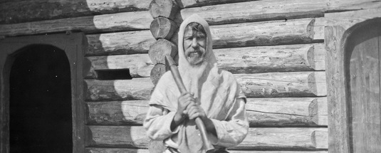 Karjalainen mies kukkeli eli huppumainen päähine päässään. Yksityiskohta. Aunus, Miinua, 1894. Kuva: Yrjö Blomstedt. Museovirasto. CC BY 4.0.