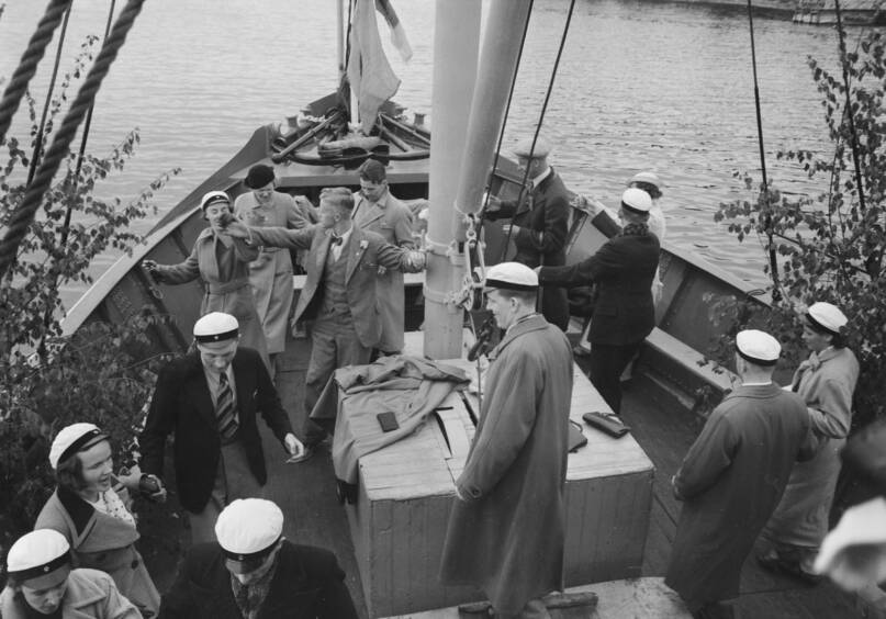 Helsingin yliopiston filosofisen tiedekunnan vuoden 1936 promootiopurjehdus pienoisristeilijä J. L. Runebergillä. Kuva: Pietinen. Museovirasto. CC BY 4.0.
