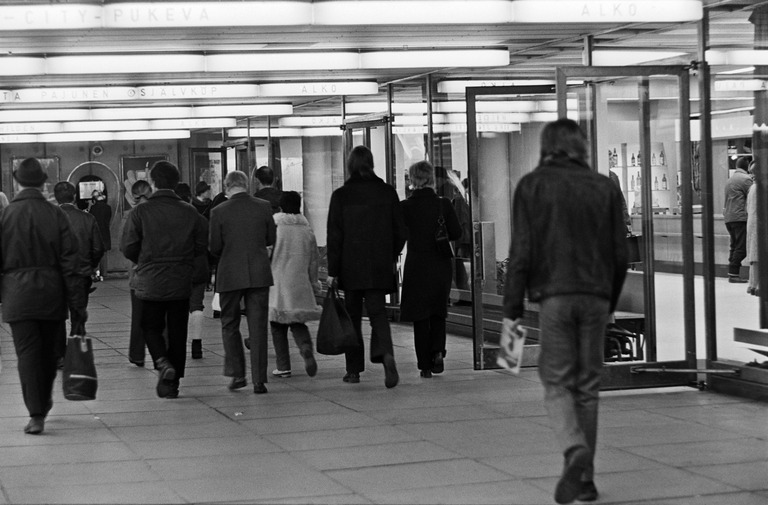 Jalankulkijoita Helsingin asematunnelissa Alkon myymälän edustalla. 1971. Kuva: Nina Hackman. Helsingin kaupunginmuseo. CC BY 4.0.