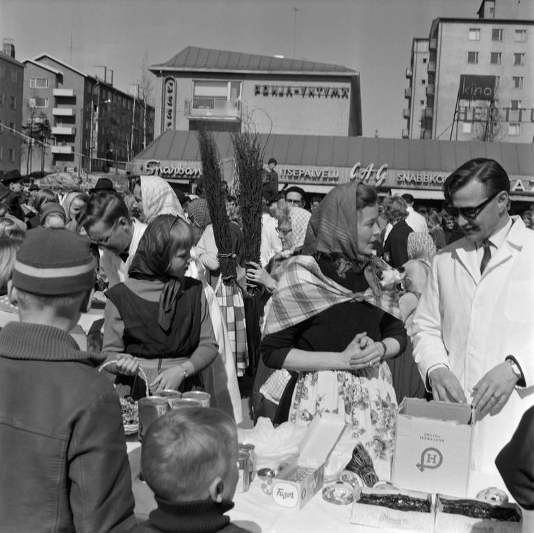 Ihmisiä Eränkävijäntorin kauppakeskuksen pihalla Herttoniemessä pääsiäisenä 1962. Kuva: Kienanen. Helsingin kaupunginmuseo. CC BY 4.0.