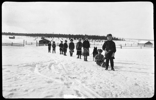 Lapset leikkivät pororaitoa eli ahkioita vetävien peräkkäin sidottujen porojen jonoa. Mutenia, Sodankylä, 1938. Kuva: Samuli Paulaharju. Museovirasto. CC BY 4.0.