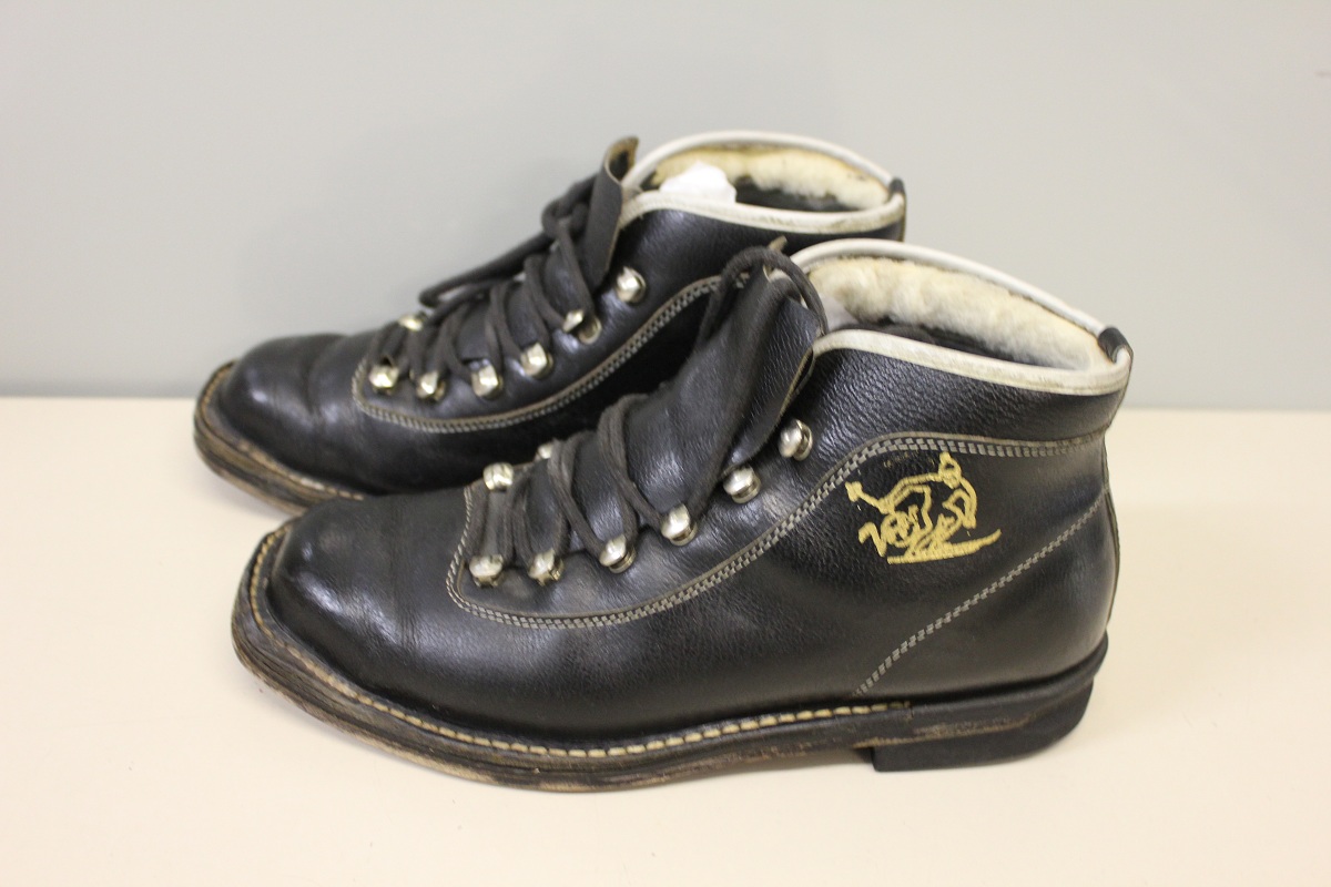 Hiihtokenkä eli hiihtomono, varressa telemark-hiihtäjän kuva. Valmistettu 1960-luvulla. Kuva: Urheilumuseo. CC BY-ND 4.0.
