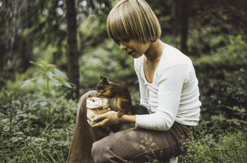 Lapsi ja orava Seurasaaressa vuonna 1974. Kuva: Märta Söderholm. Museovirasto. CC BY 4.0.